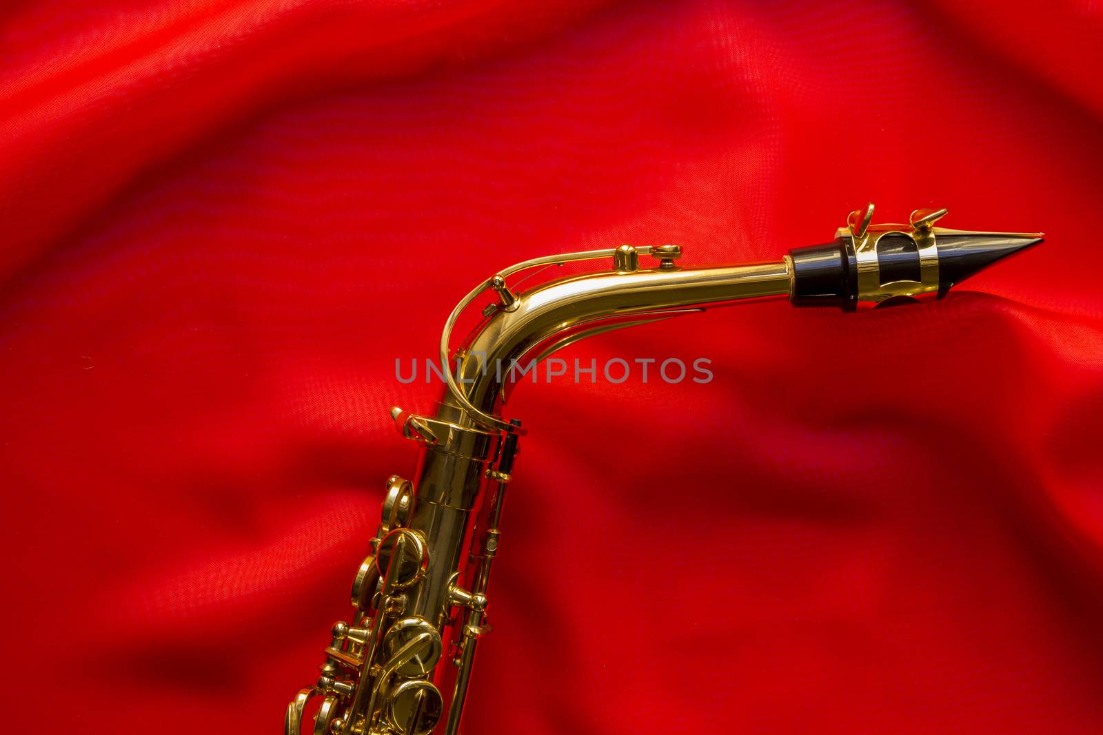 beautiful golden saxophone on delicate red silk background