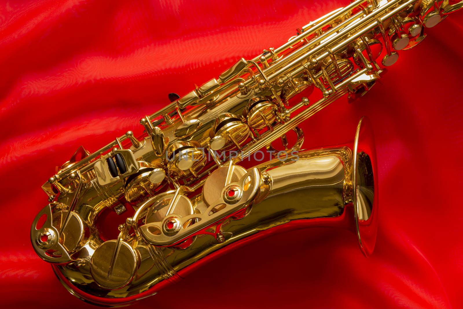 beautiful golden saxophone on delicate red silk background
