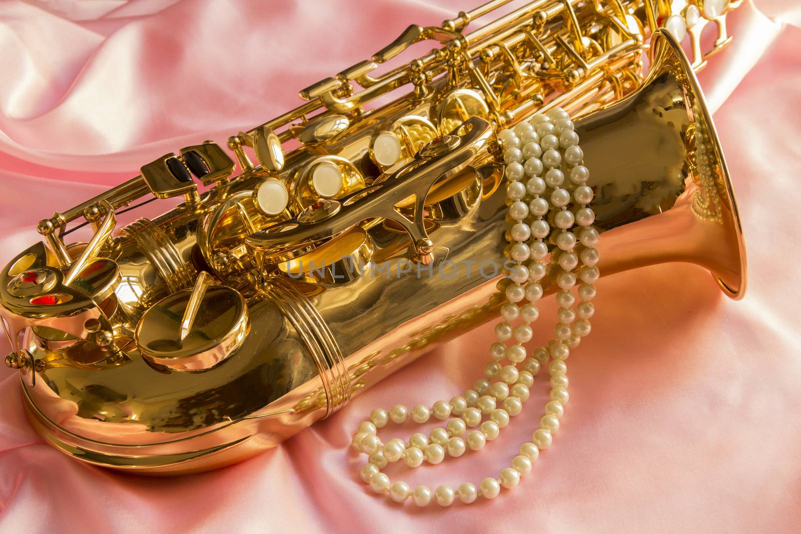 Saxophone and Pearl necklace on Pink silk fabric soft