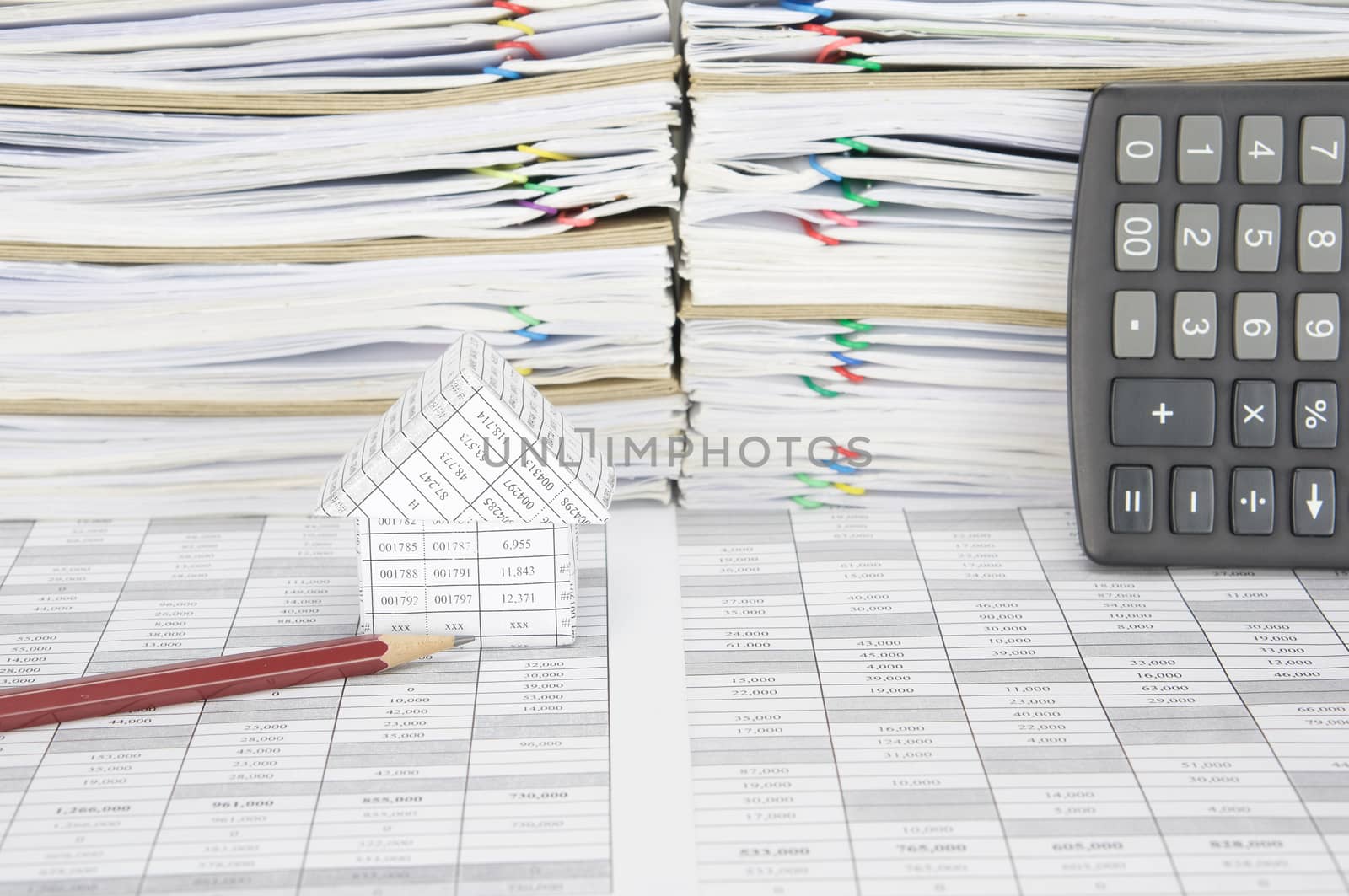 Brown pencil with house on finance account have overload of paperwork with colorful paperclip and envelope with calculator place vertical as background.