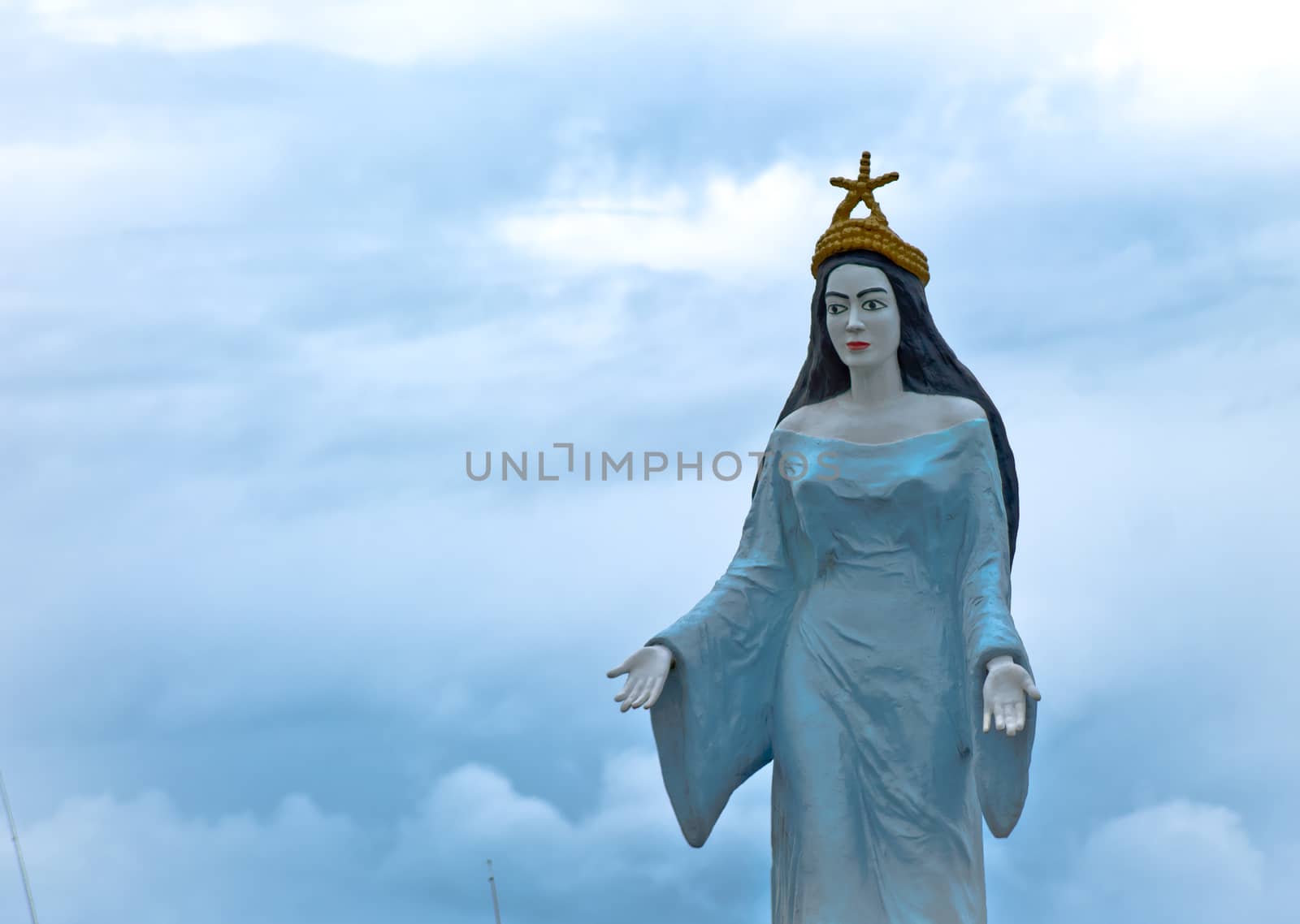 Statue of Iemanja with blue cloudy sky in the background