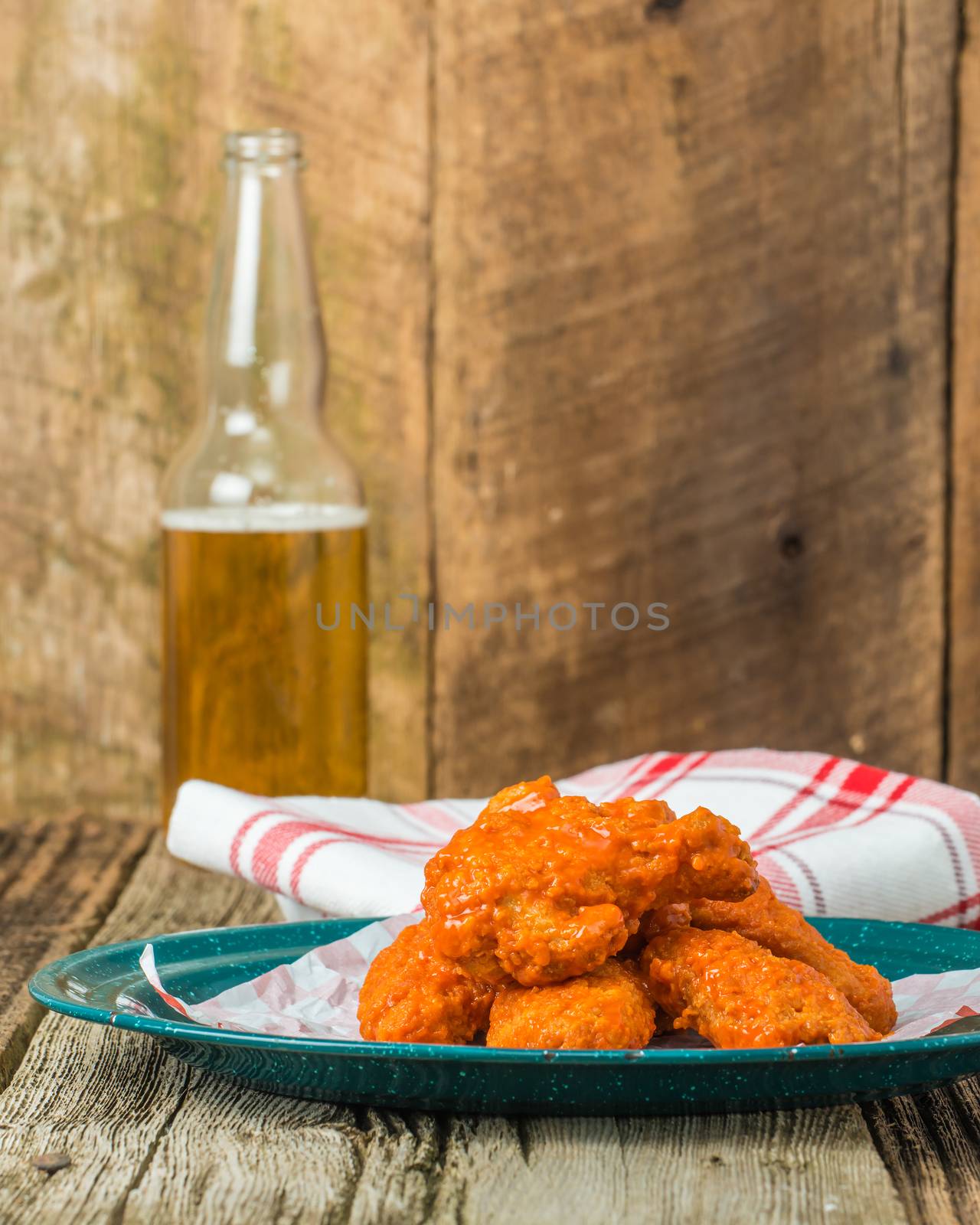 Spicy buffalo style chicken wings on a plate and beer.