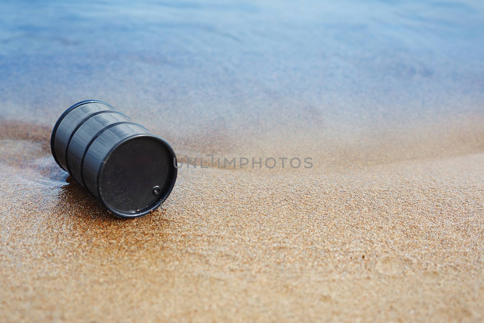 Oil barrel abandoned at the sea coast