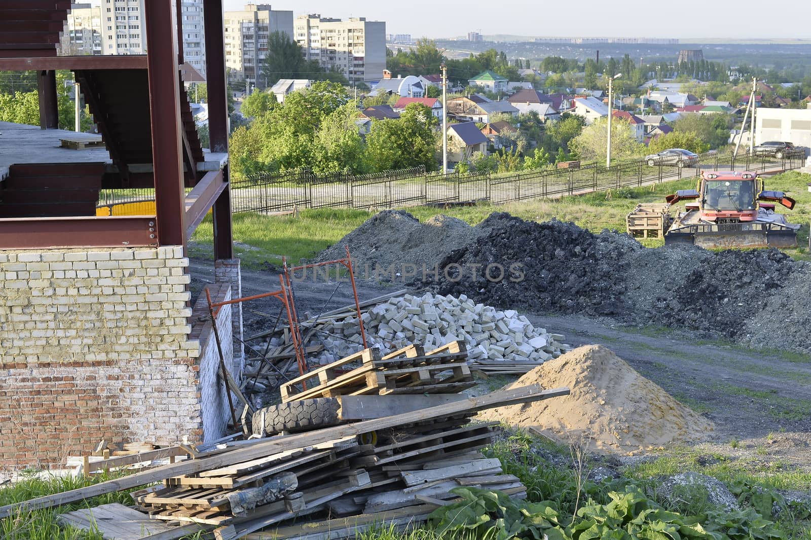 Construction materials and waste on the background of building under construction.