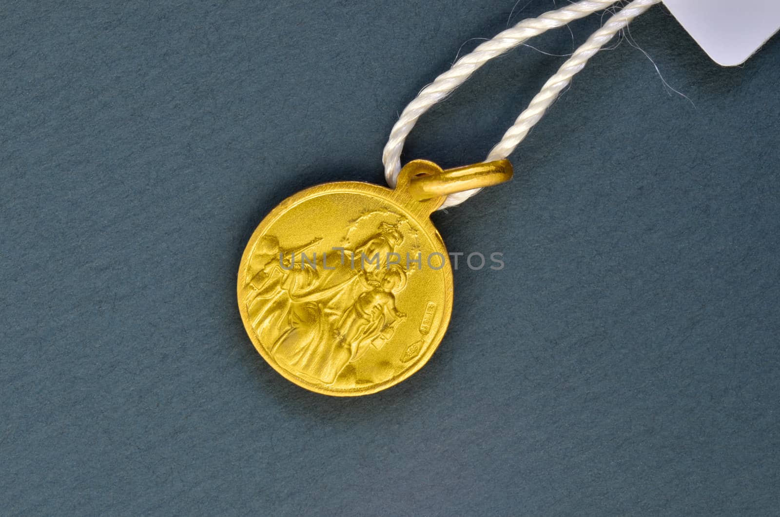 Golden scapular pendant traditionally given for first communion gift. Macro image.