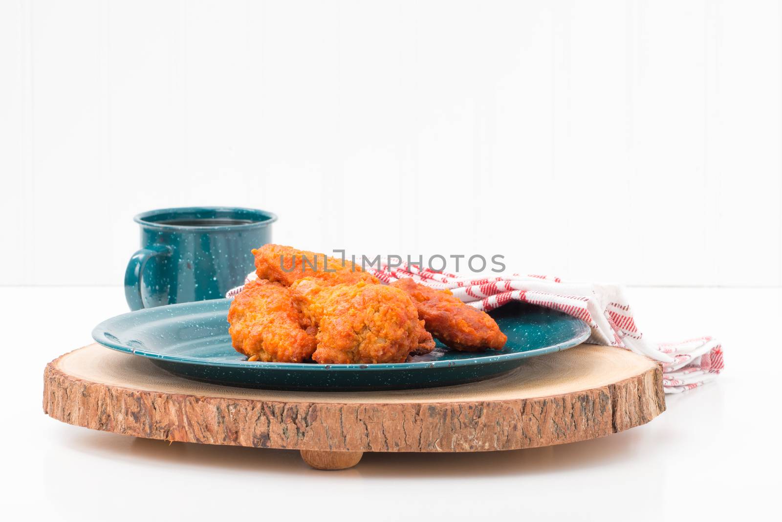 Spicy hot buffalo style chicken wings on a tin plate.