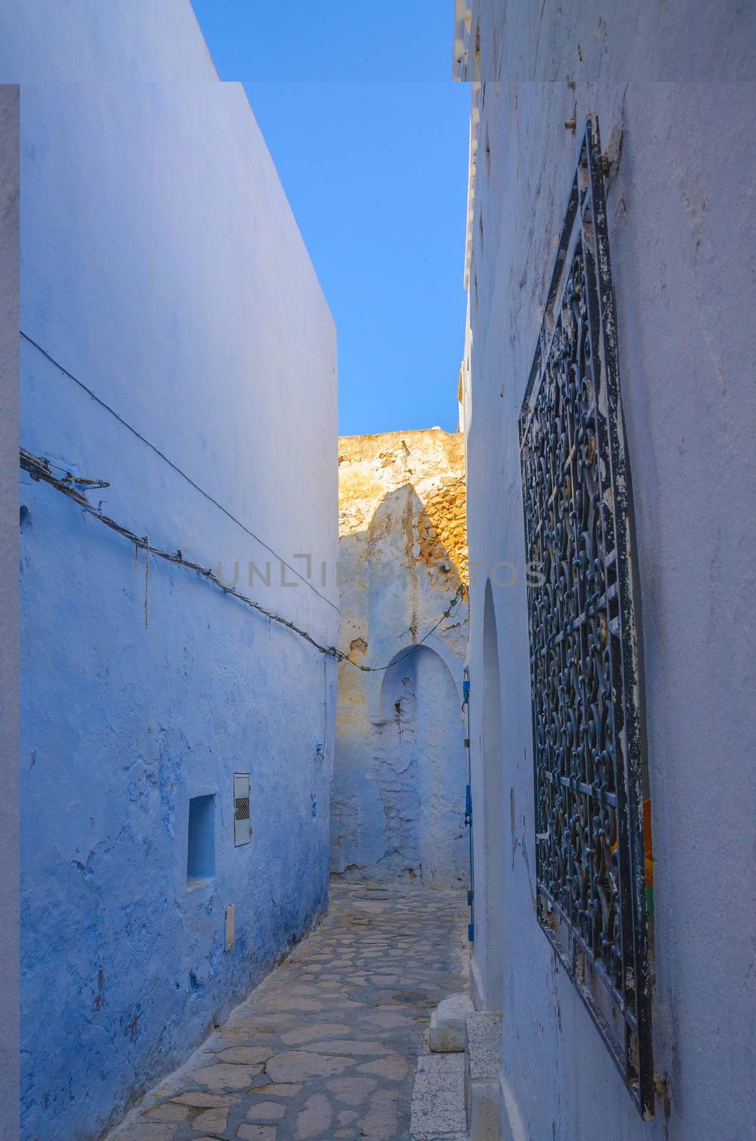 Oriental narrow street with blue houses in Medina, Hammamet Tunisia.