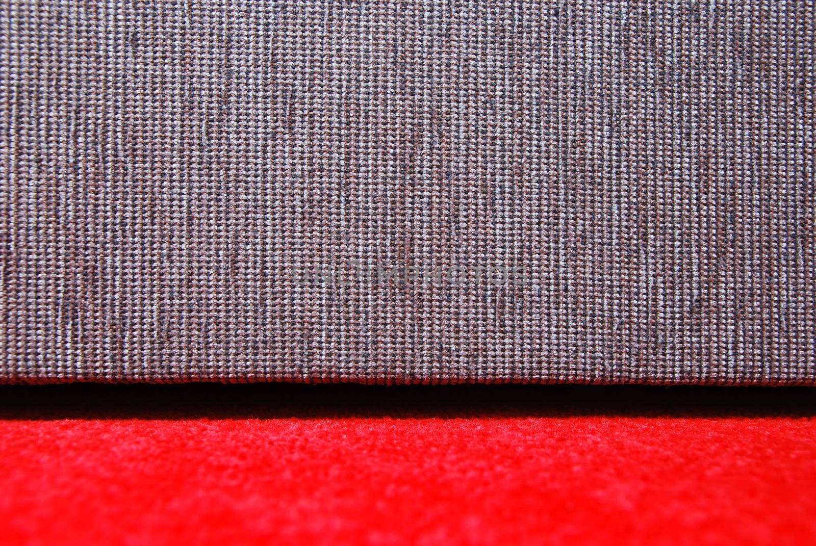 Detail of red carpet and grey sofa.