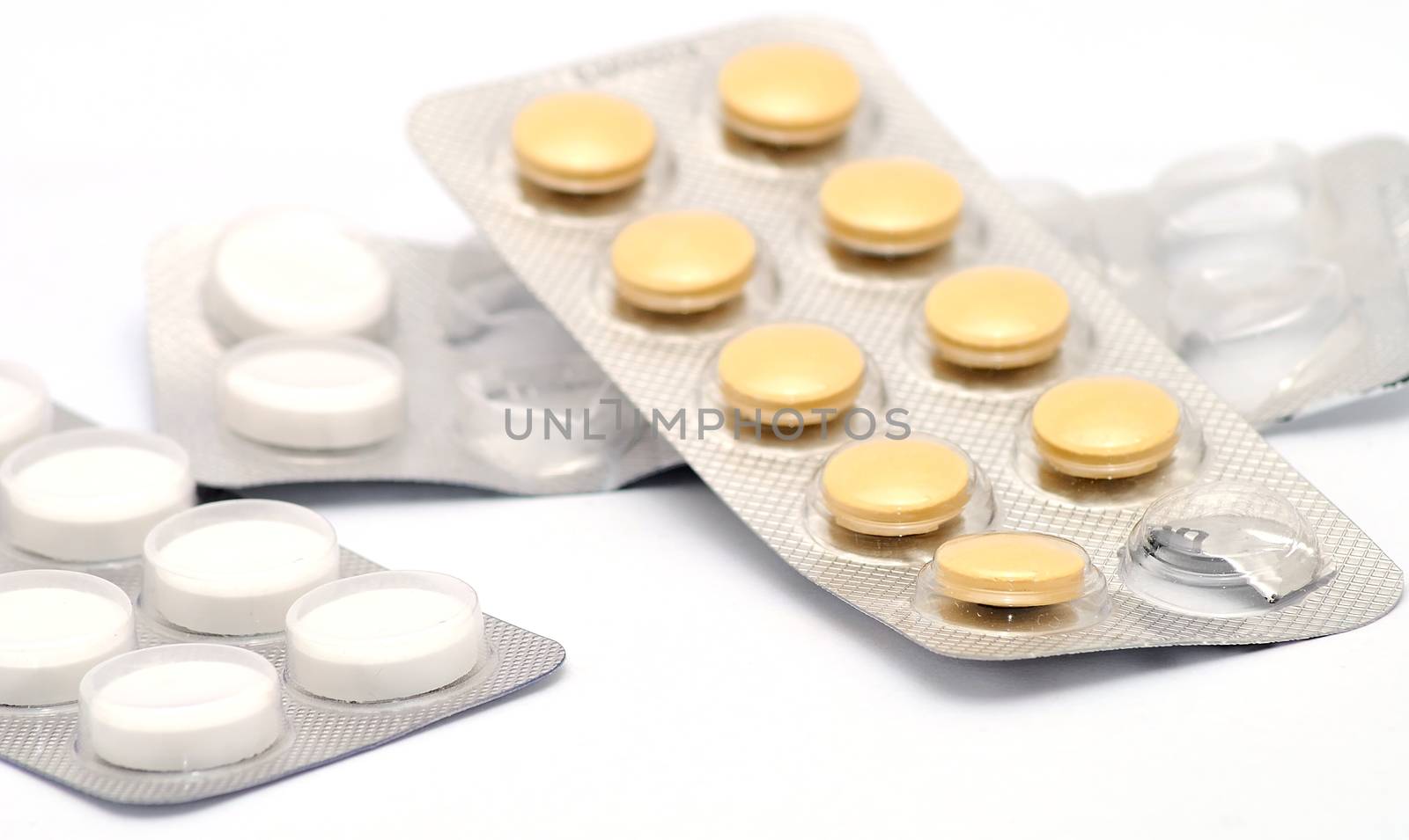 White and brown pills in opened boxes placed on white background.