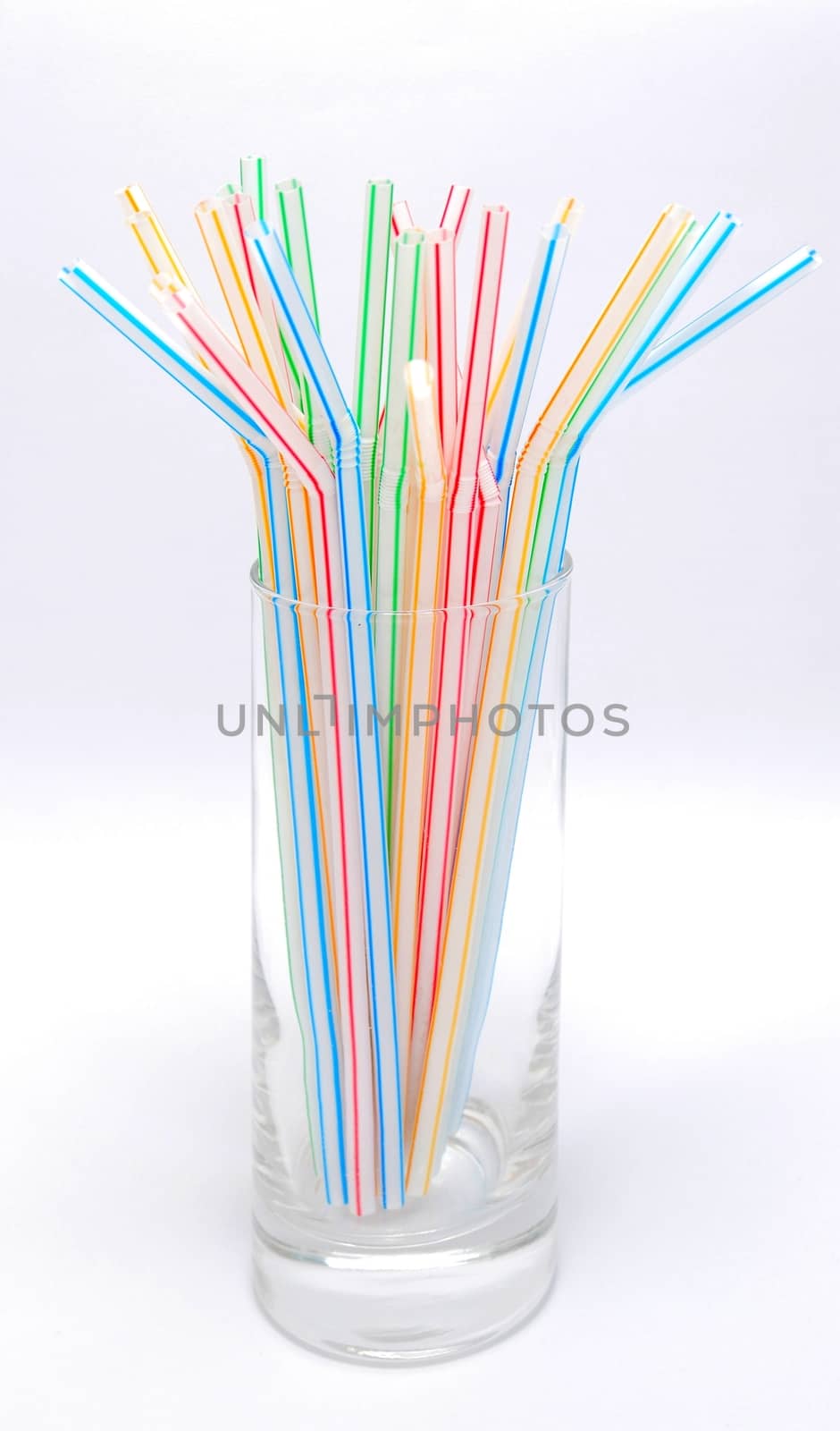 Color straw in glass isolated on the white background.