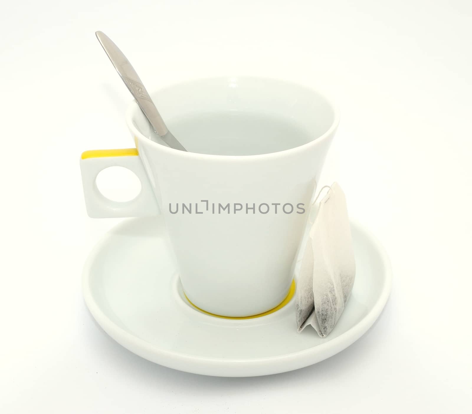 White cup of tea with silver teaspoon on the white background.