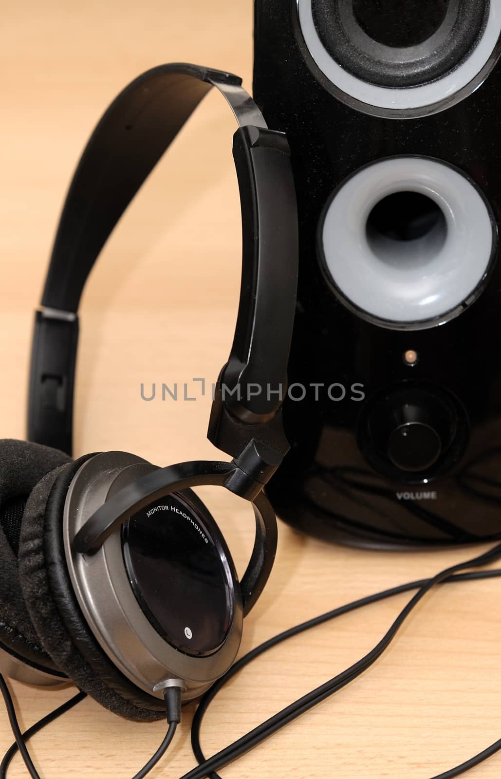 Black design headphones rest against the loudspeaker.