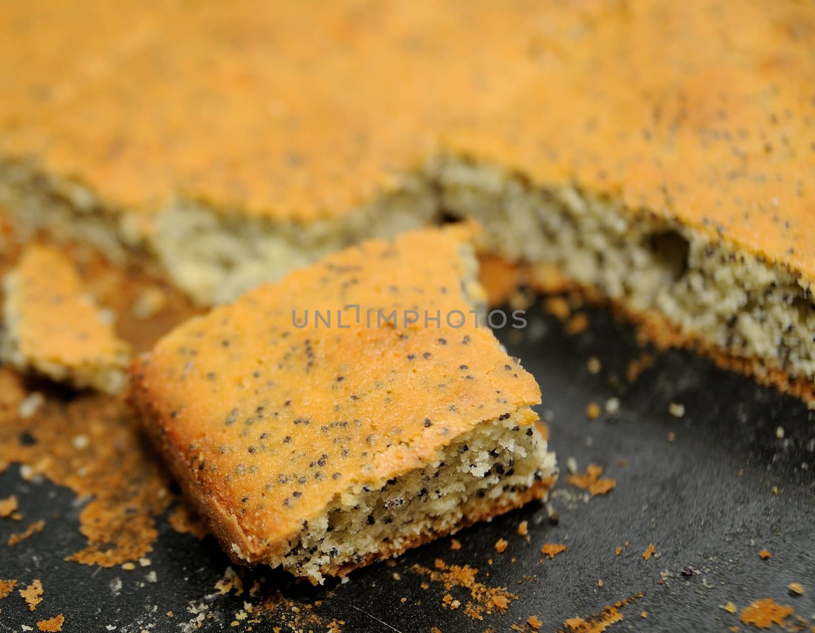 Cut piece of poppy cake on the pan.