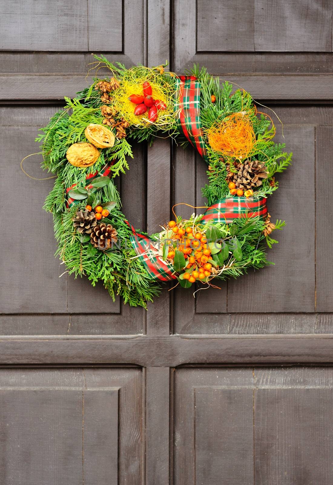 Nice Christmas wreath hanged on the wood door.