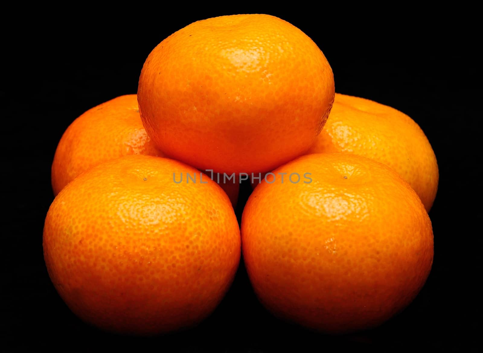 Stack of mandarines placed on the black background.