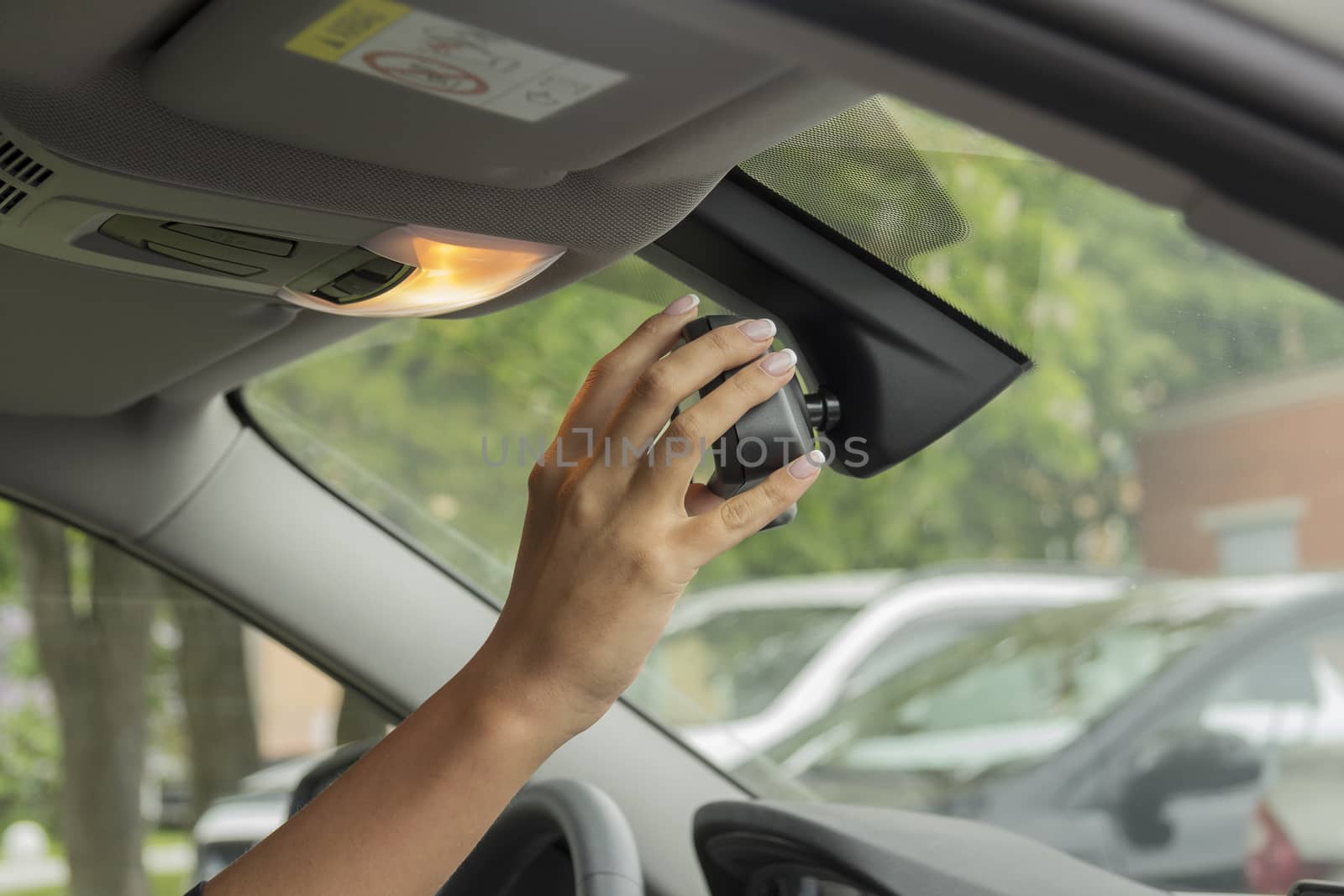 girl adjusts the rearview mirror
