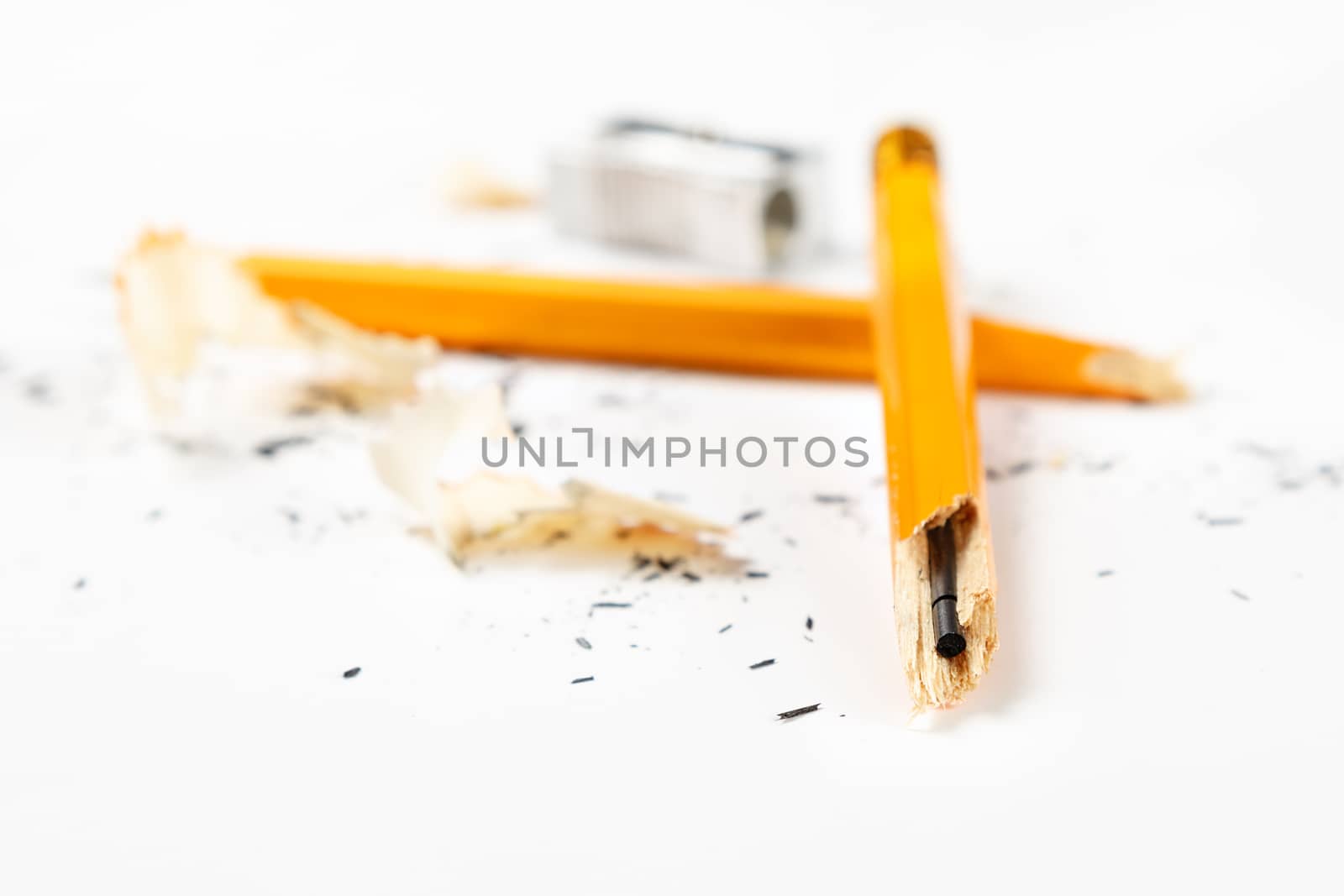 Pencil, metal sharpener and pencil shavings on white background. Horizontal image.