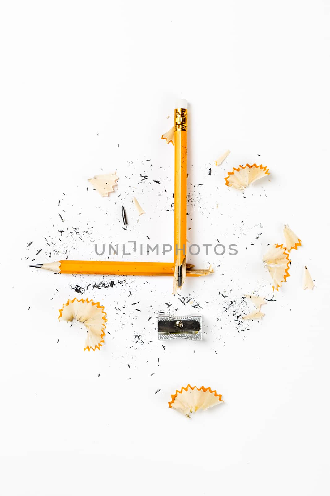 Pencil, metal sharpener and pencil shavings on white background. Vertical image.