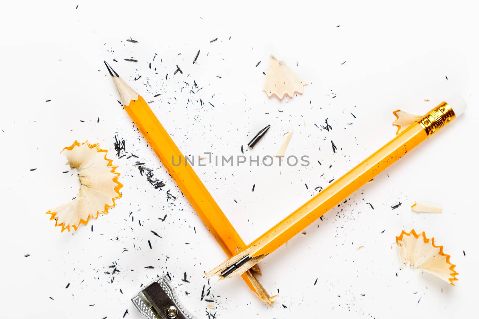 Pencil, metal sharpener and pencil shavings on white background. Horizontal image.
