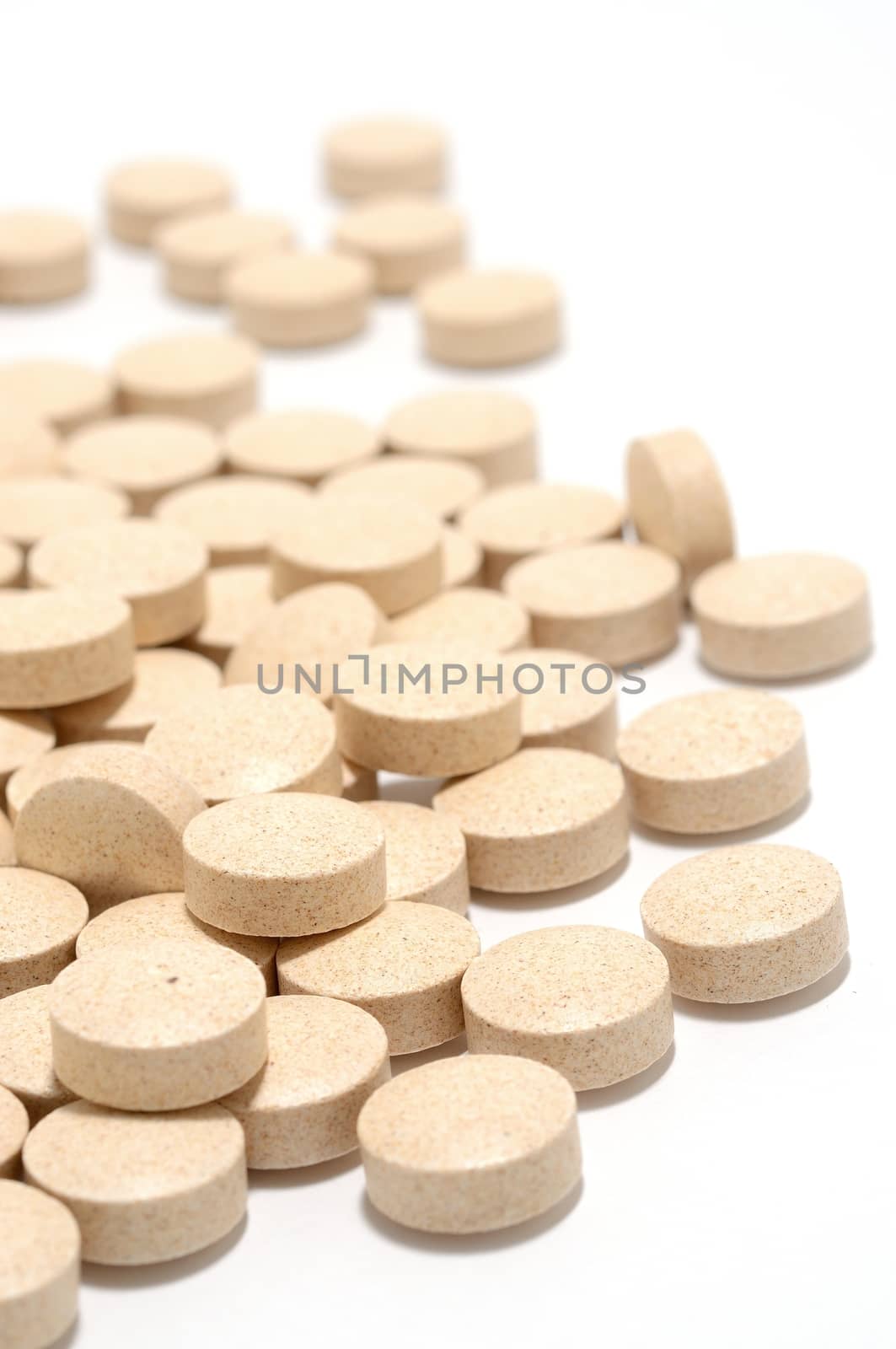 Macro shot of brown tablets on a white background.