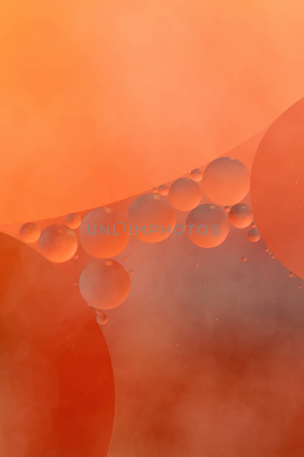 Abstract red, orange background from floating oil bubbles in the water.