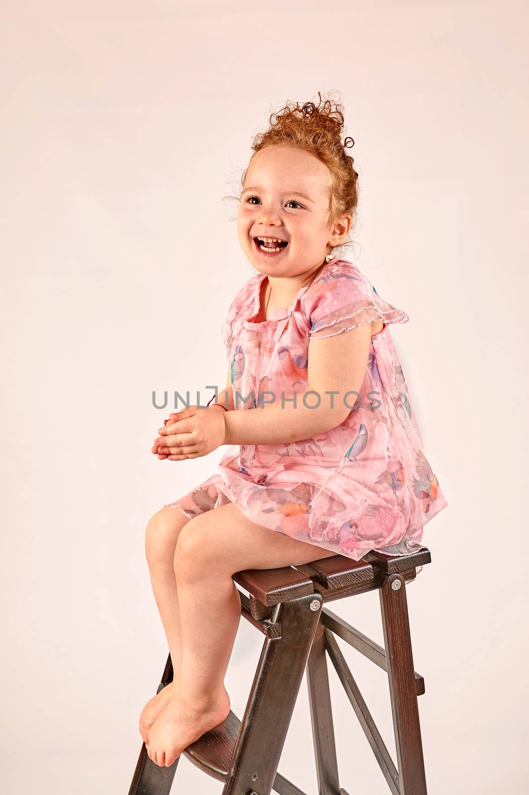 Fashion little girl in rose dress, in catwalk model pose, stock photo