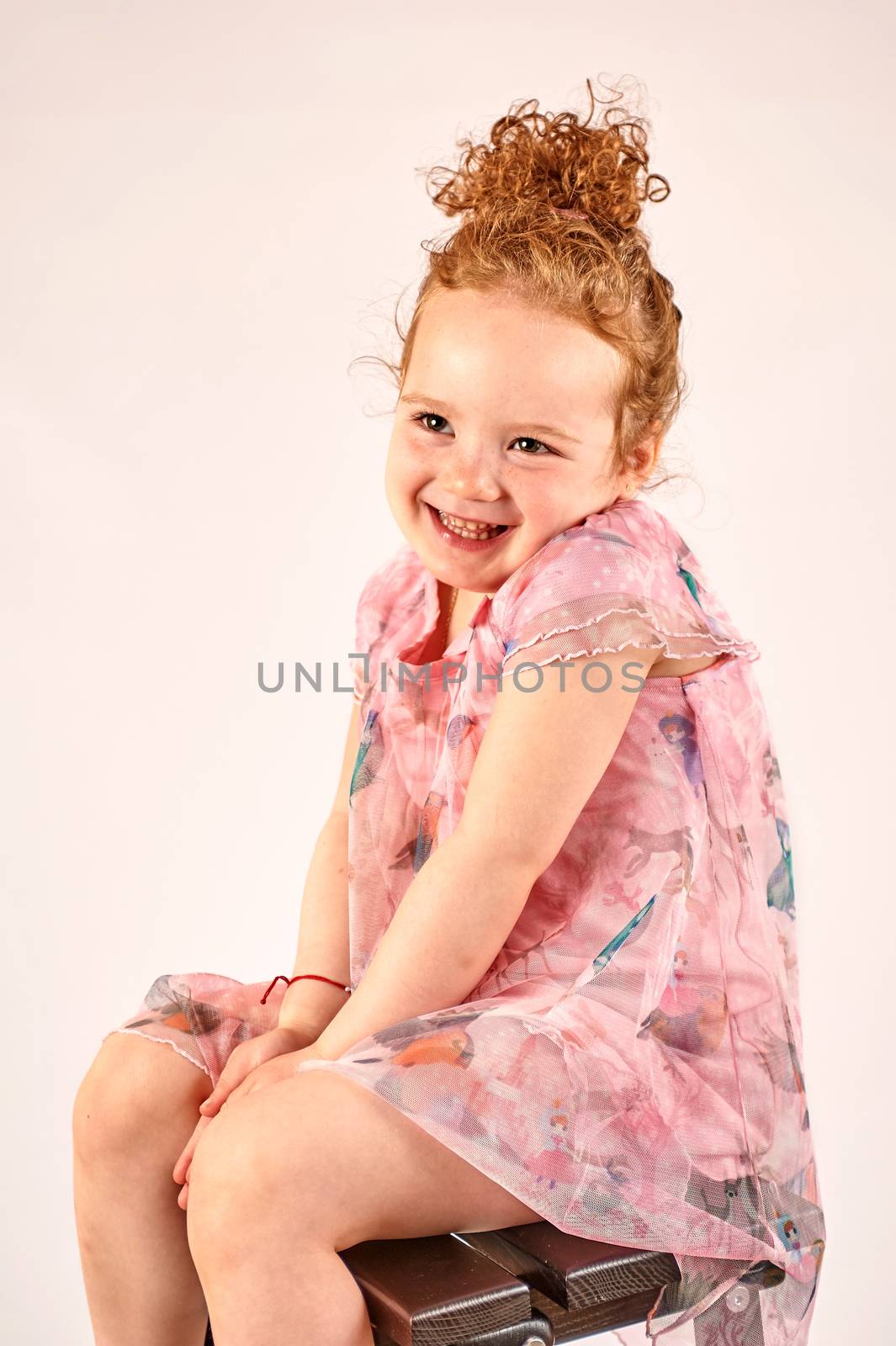 Fashion little girl in rose dress, in catwalk model pose, stock photo