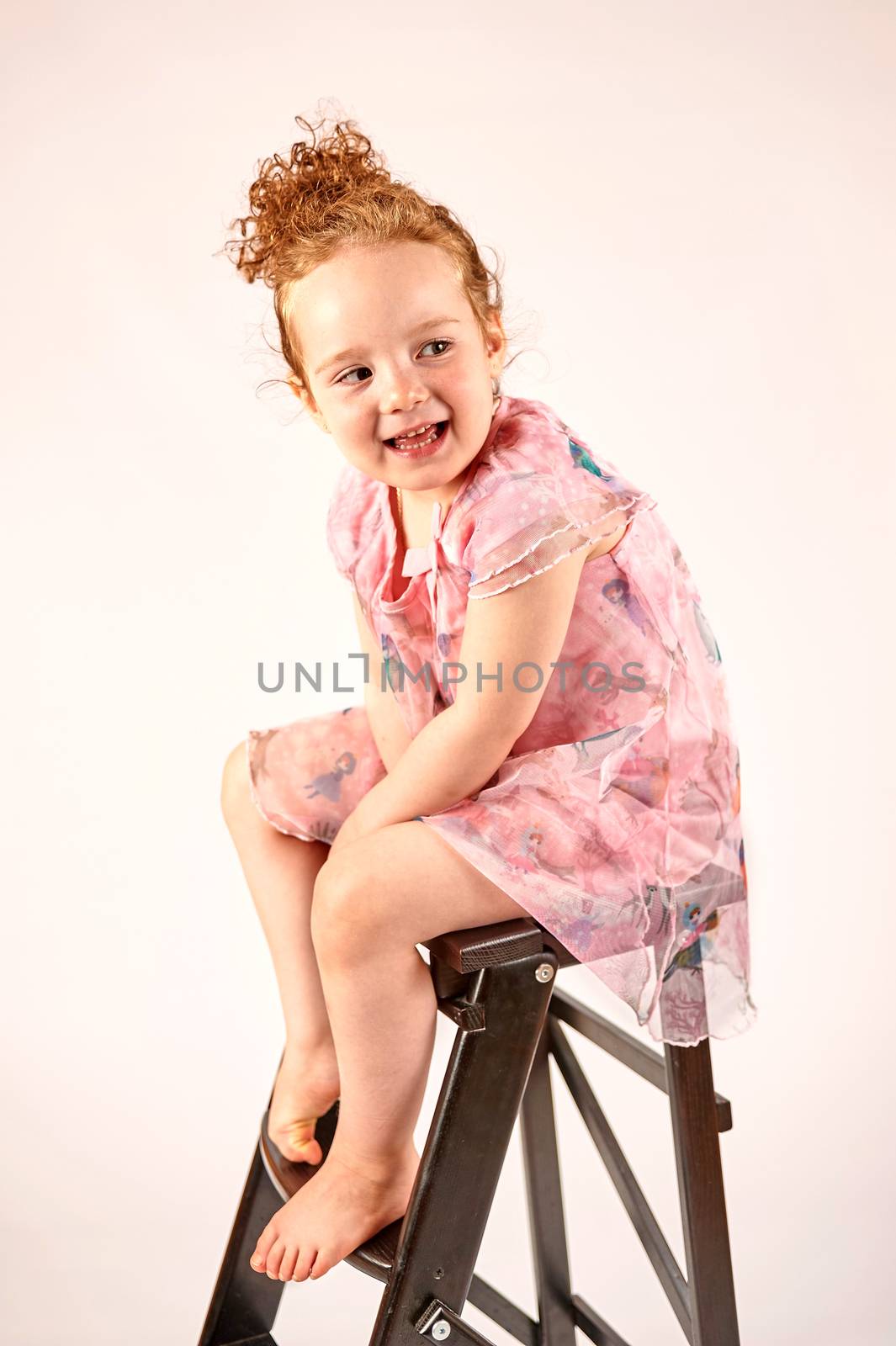 Fashion little girl in rose dress, in catwalk model pose, stock photo