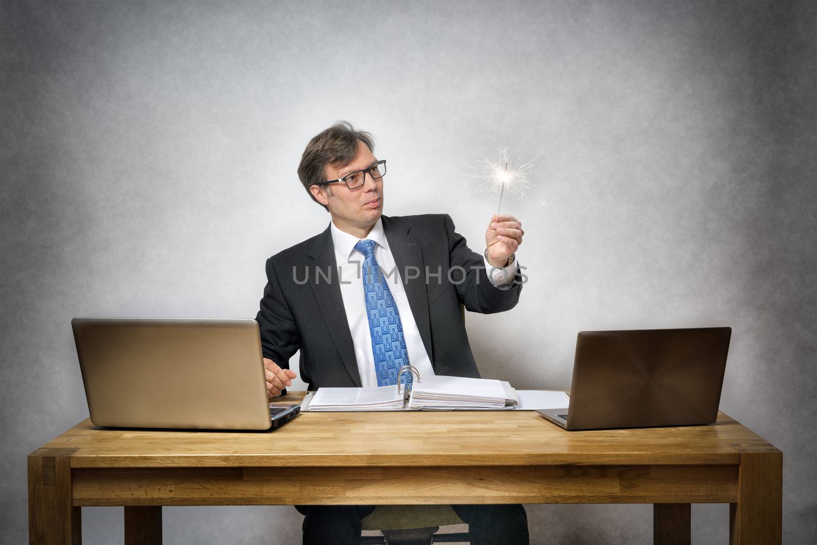 Image of business man with sparkler in office