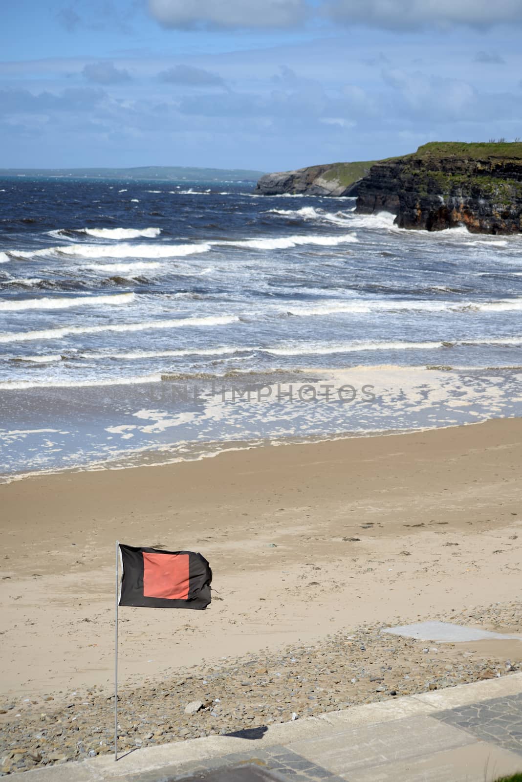 quicksilver flag flying beside surf school with ballybunionbeach and cliffs in background
