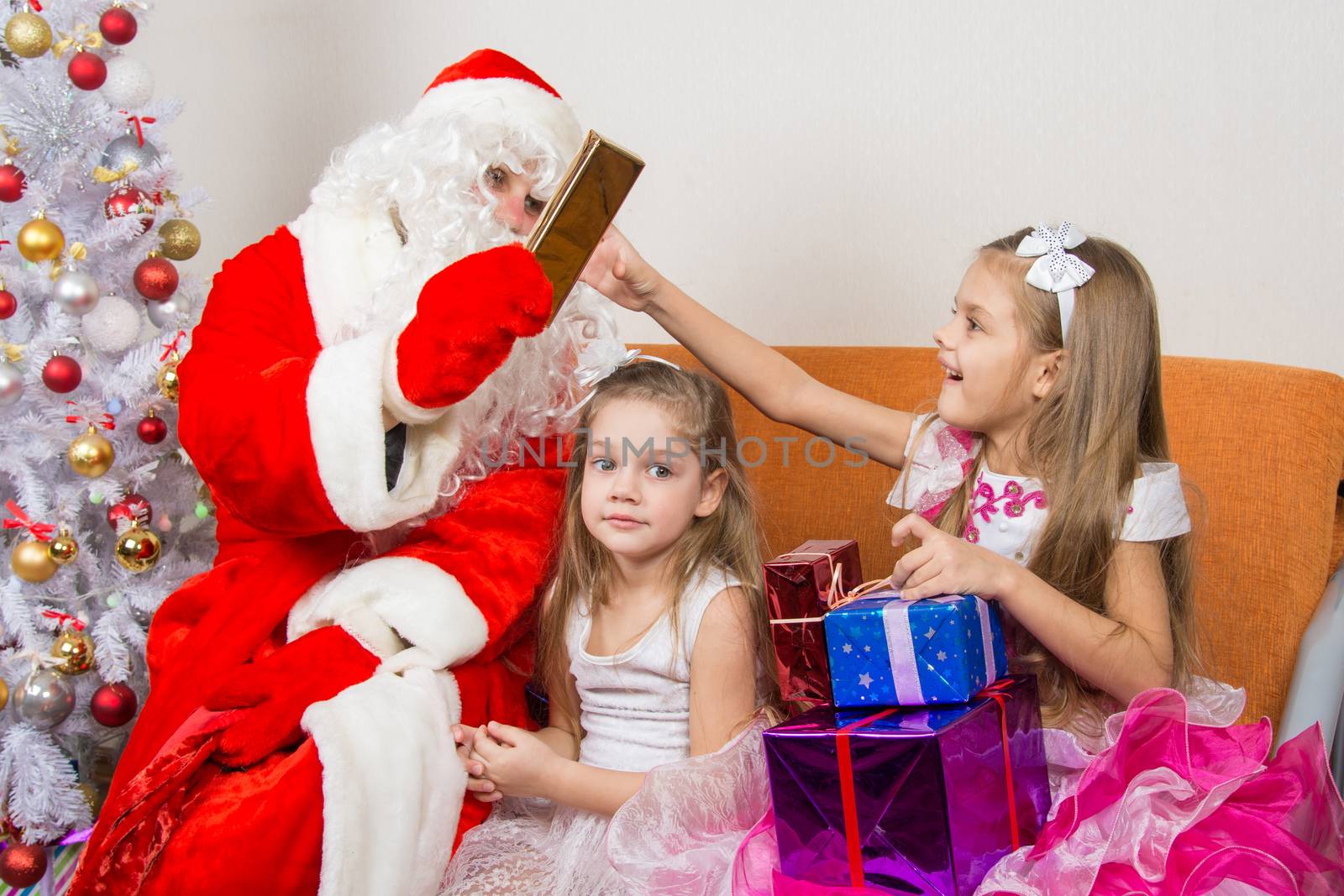 Santa Claus gives gifts to one girl, the other sitting in the waiting by Madhourse