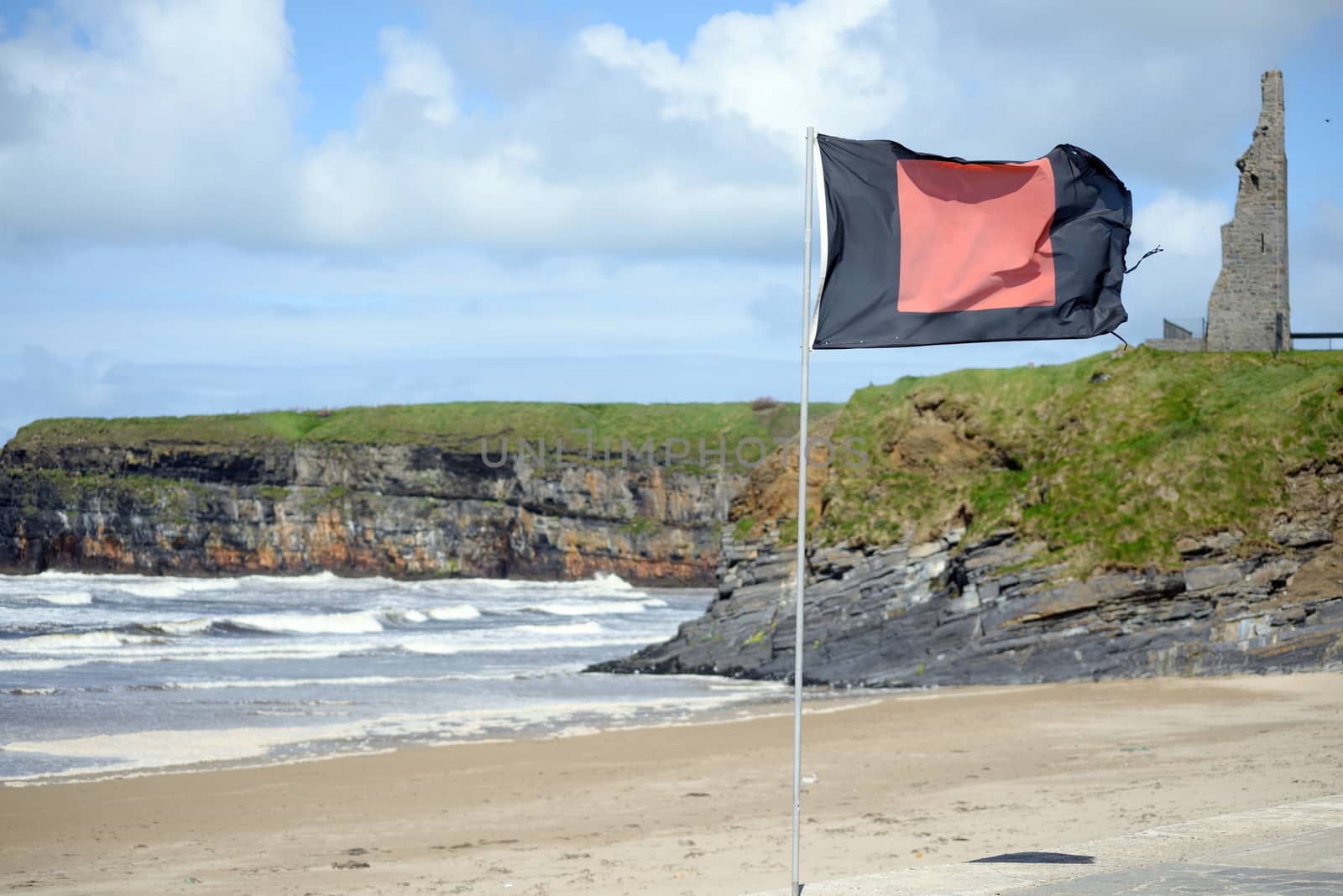 quicksilver flag flying beside surf school with ballybunion castle in background