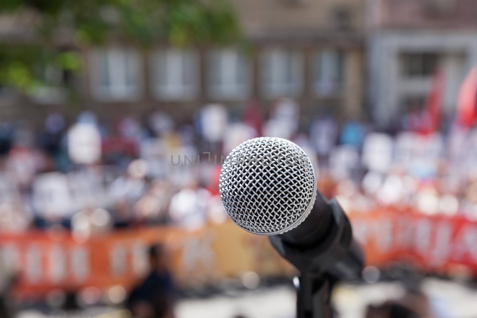 Microphone in focus against unrecognizable crowd
