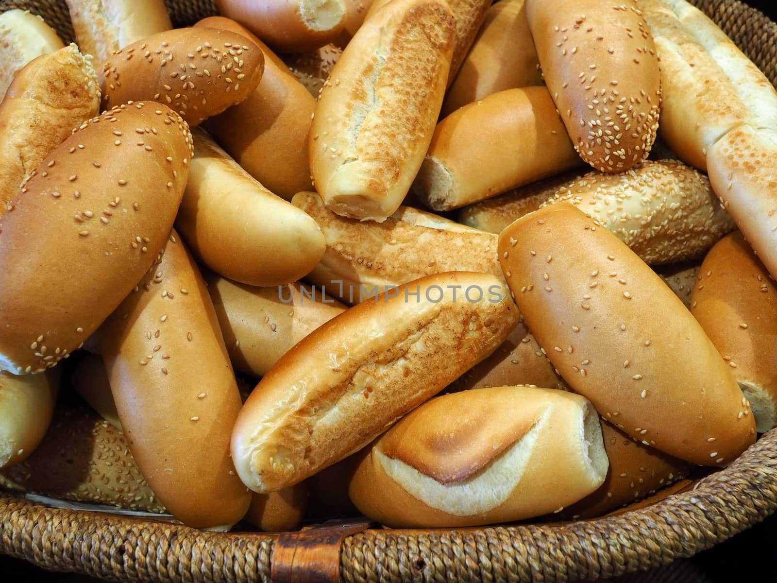 Freshly baked buns on display in a basket at the bakery