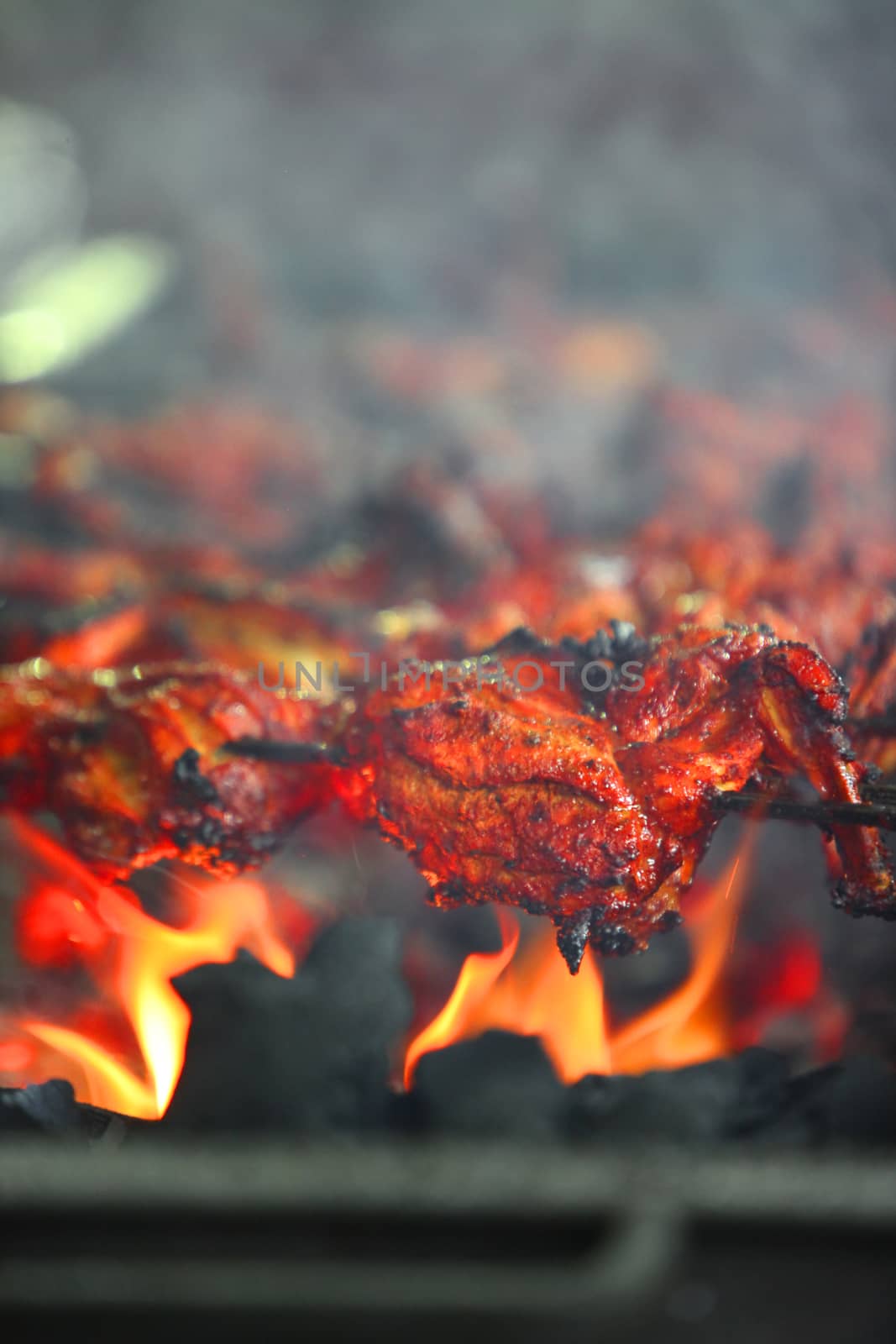 Delicious tandoori chicken being prepared on a grill in an Indian hotel.