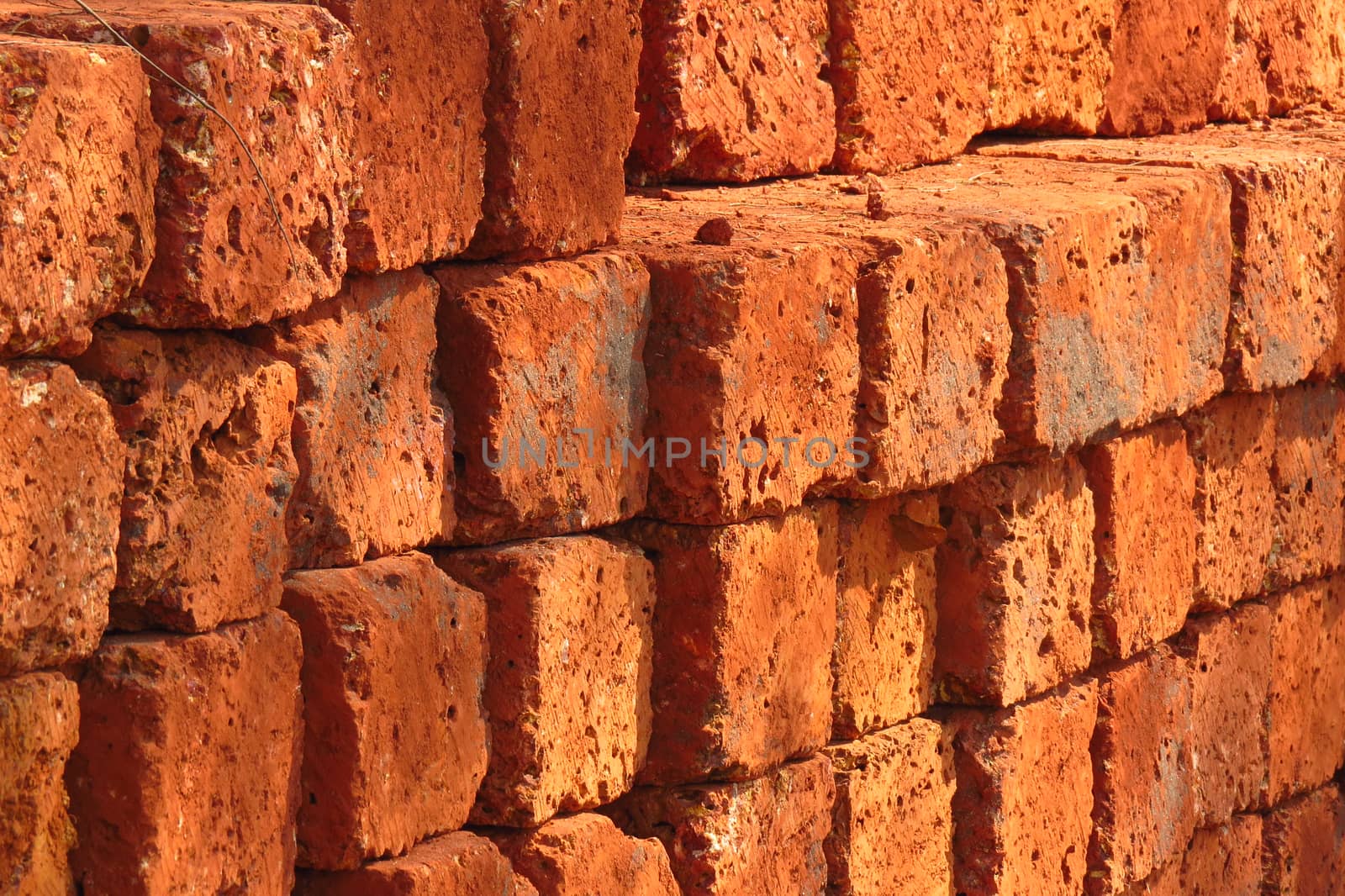 A background of a stack of red bricks at a construction site.                               