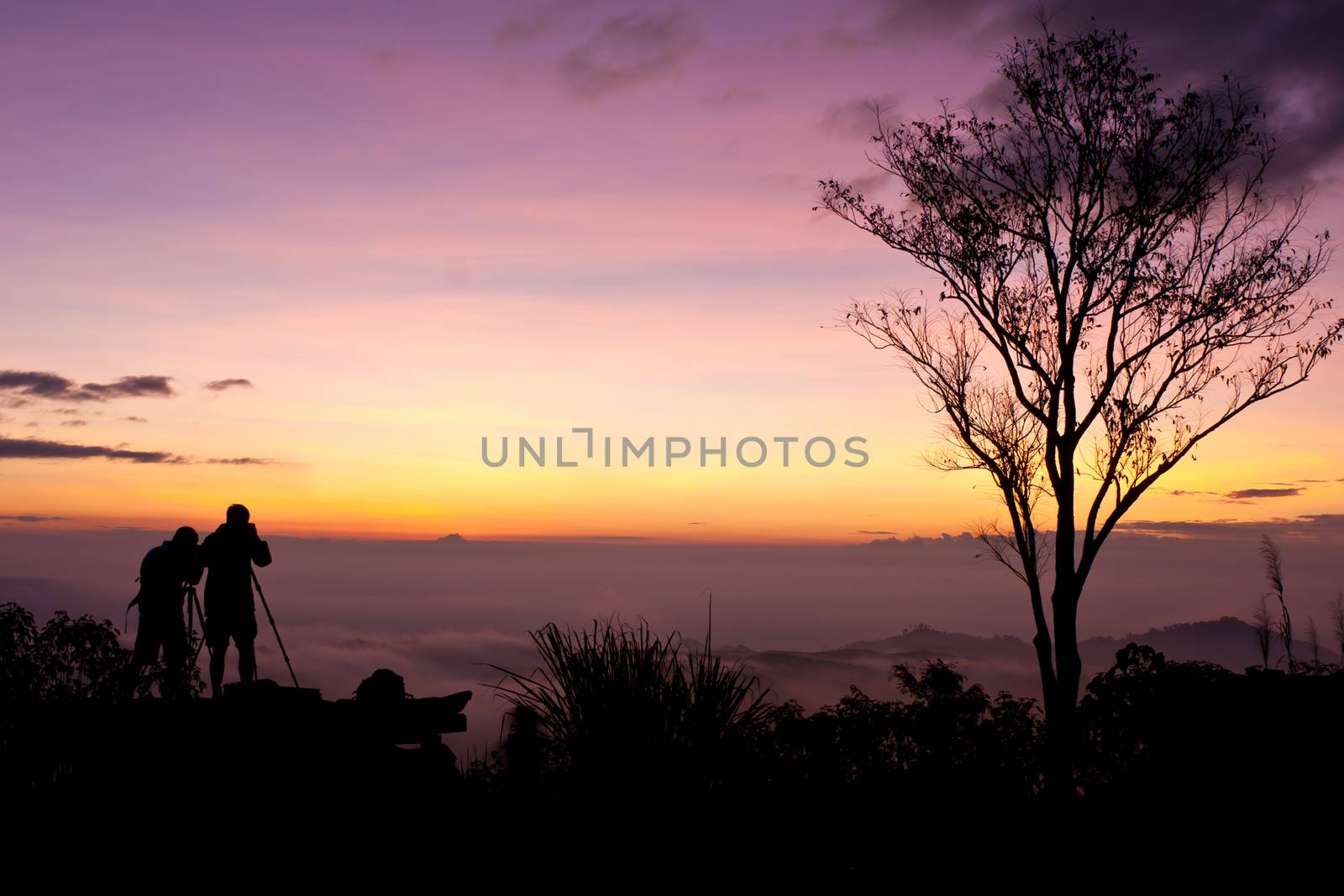 Young men silhouette taking photos about landscape outdoor  by ekachailo