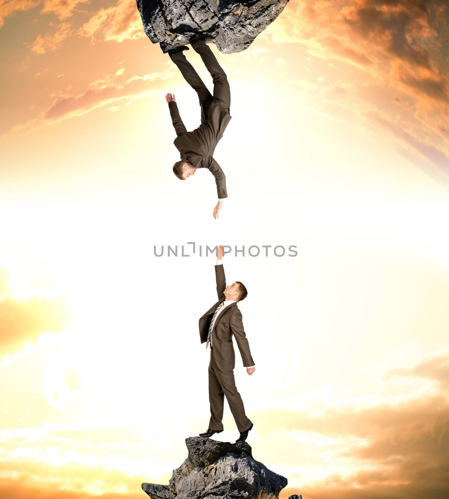 Two businessmen on rocks attracted to each other isolated on sunset sky background