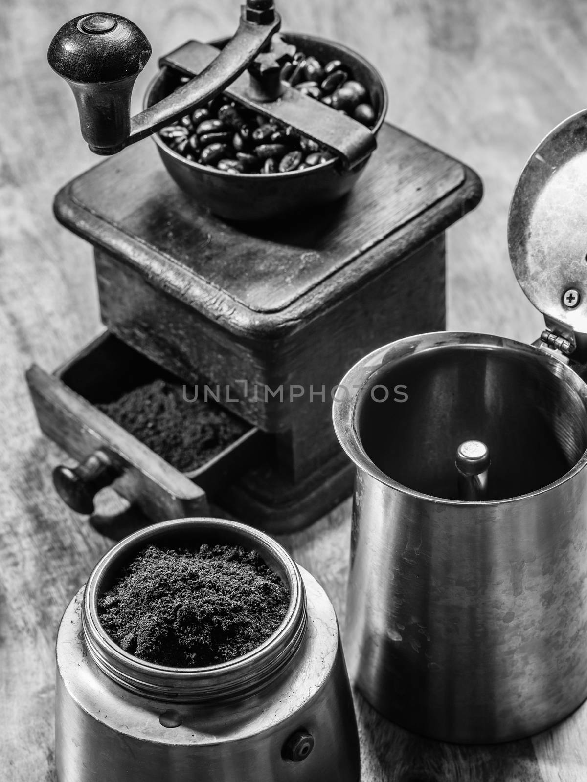 Photo of an Italian Moka Express stovetop coffee maker and a coffee grinder done in black and white.
