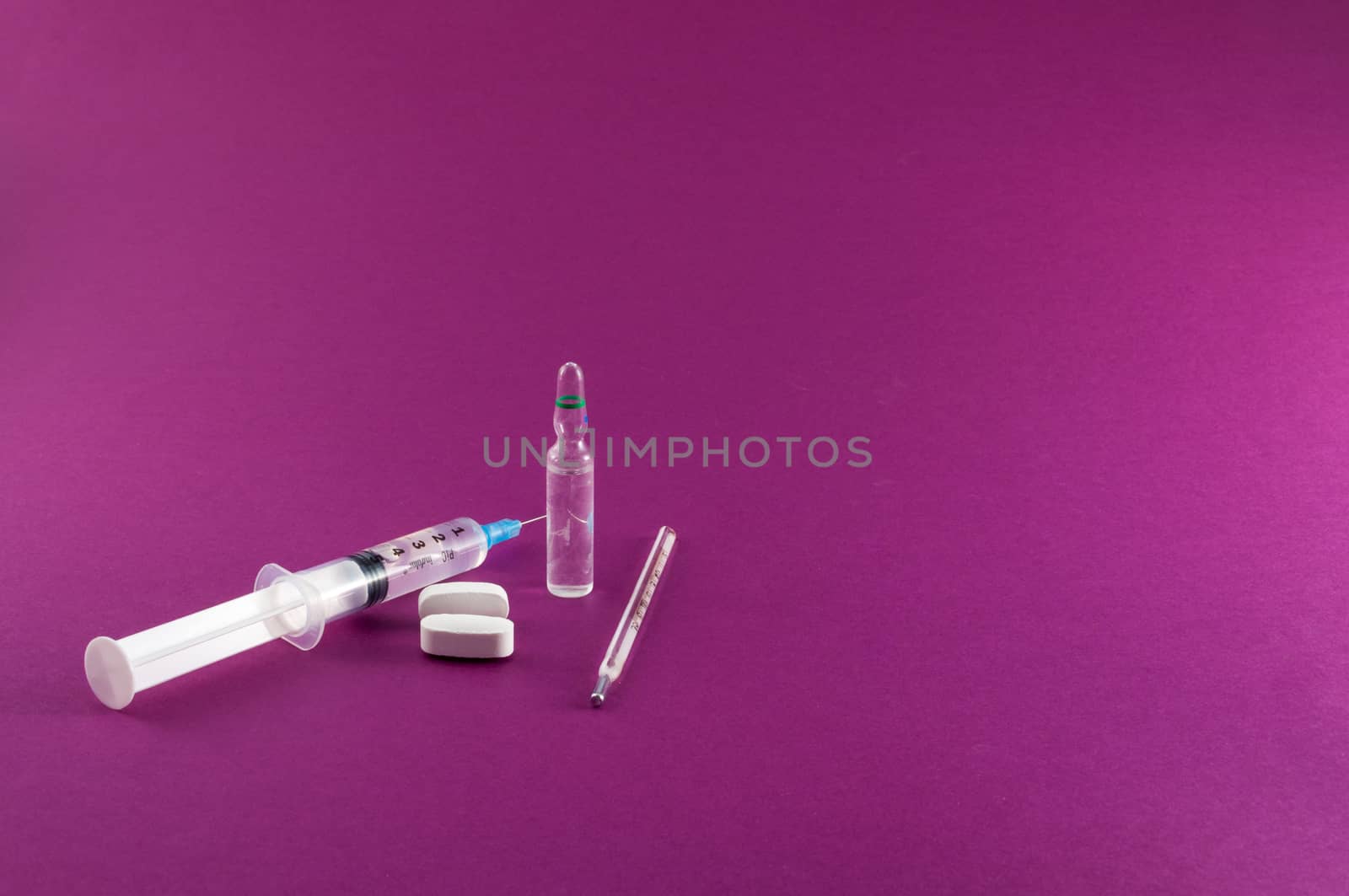 Closeup of medical tools and drugs on colored background