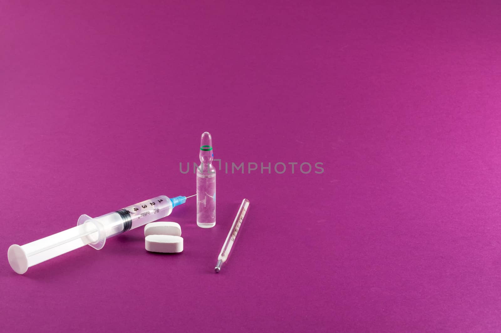 Closeup of medical tools and drugs on colored background