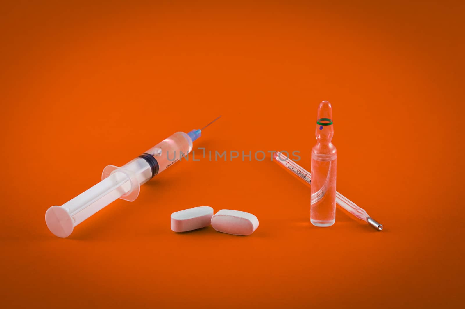 Closeup of medical tools and drugs on colored background