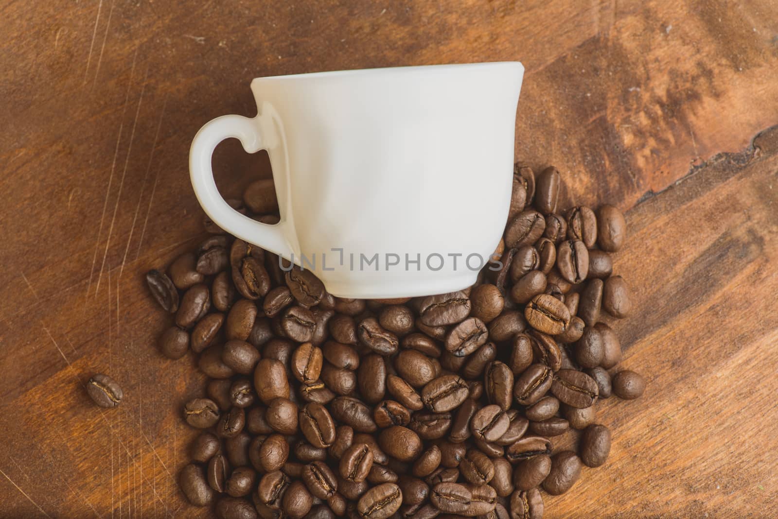 top view pile of cofee beans and cup laying above by skrotov