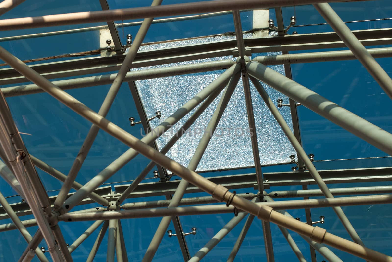 Bottom view of modern glass roof in business district in evening with broken glass by skrotov