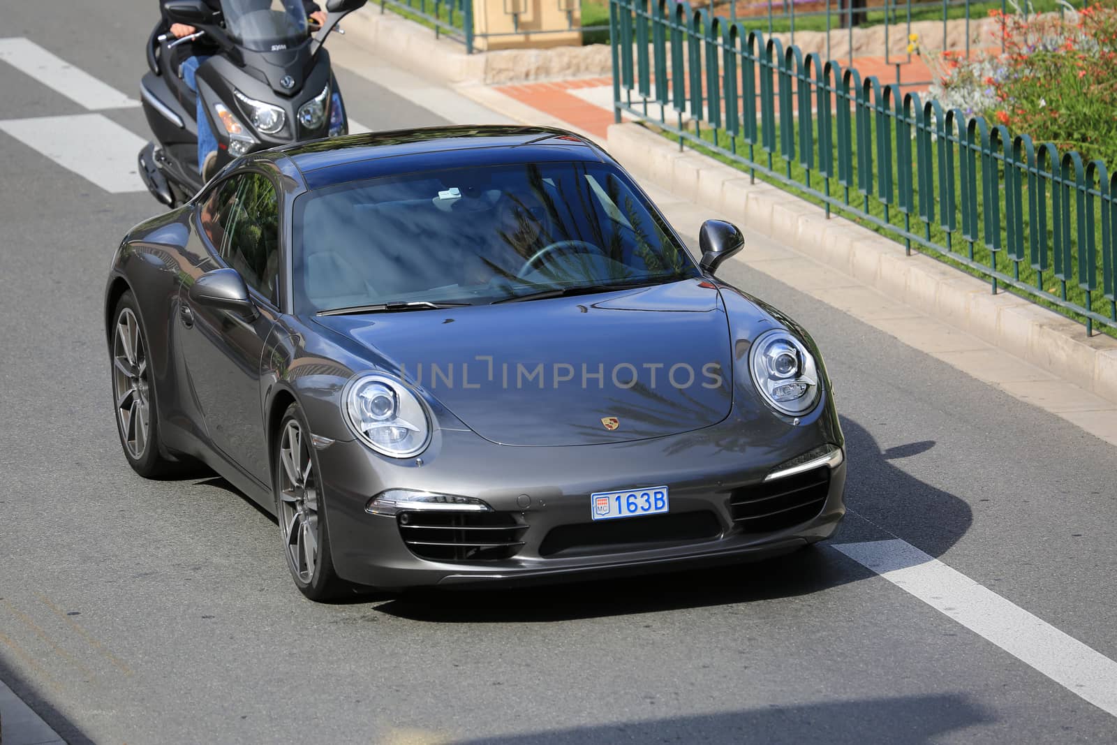 Monte-Carlo, Monaco - May 18, 2016: Beautiful Woman Driving an Expensive Porsche 911 Carrera S on Avenue Princesse Grace in Monte-Carlo, Monaco in the south of France