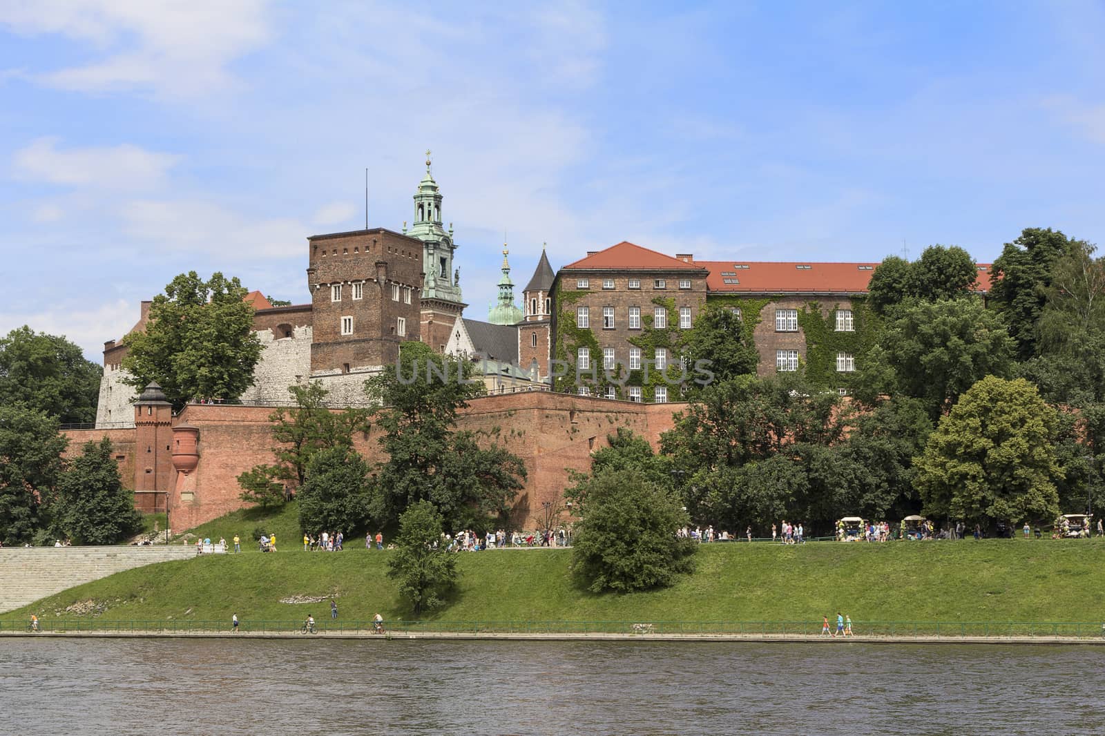 KRAKOW, POLAND - JUNE 17, 2013 : View on Wawel Royal Castle and Vistula boulevards.  Place often visited by tourists and locals for purposes of relaxation on sunny days.
