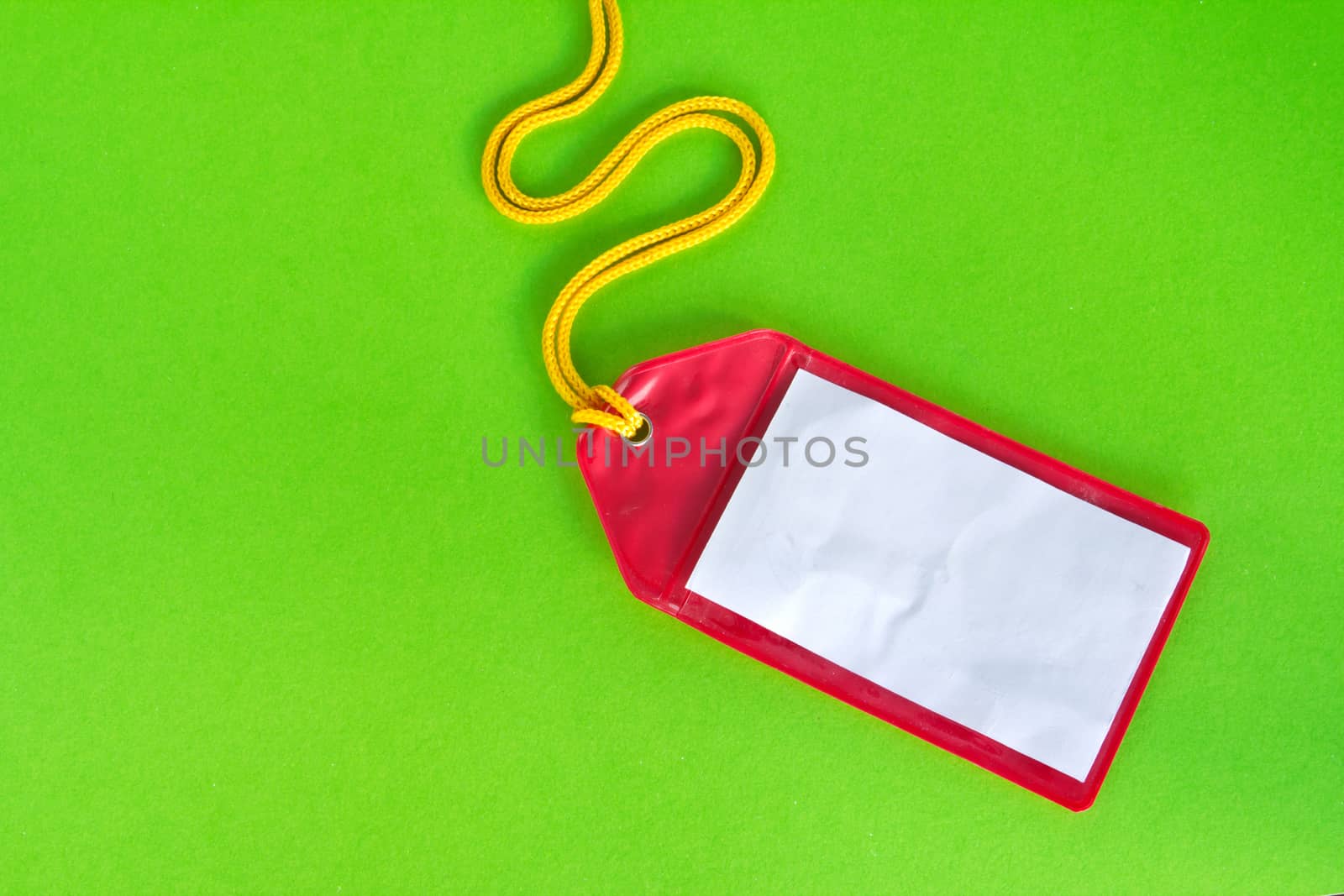 Rad plastic luggage tag isolated on green background 