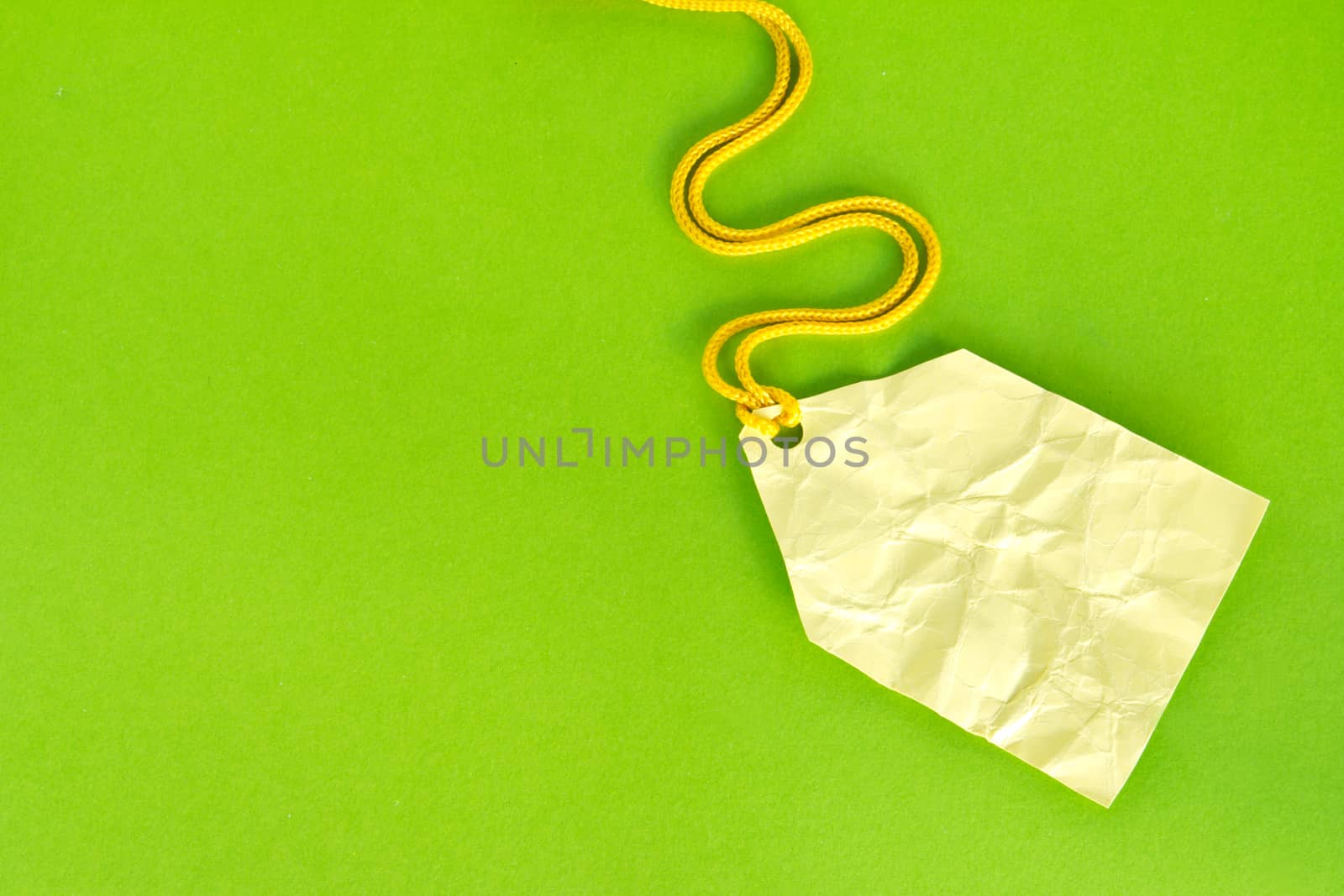 Blank yellow price tag isolated on green, Price tag, gift tag, sale tag, address label, etc. 
