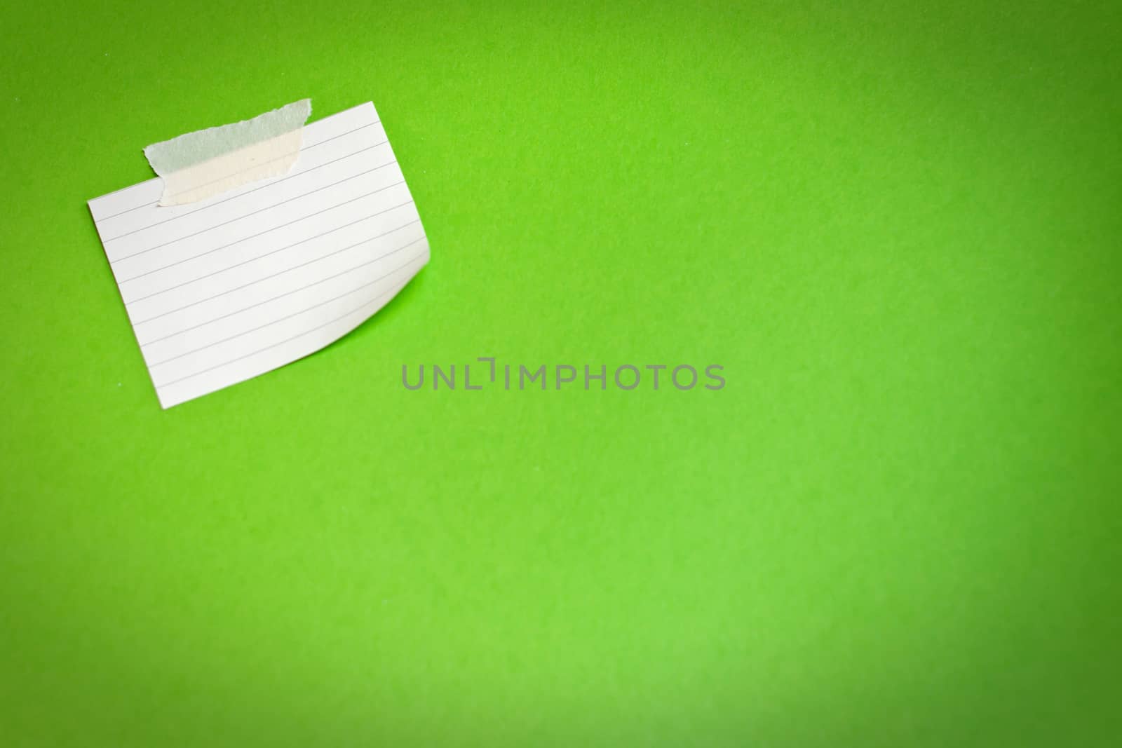 White note paper attached on green background  by ekachailo