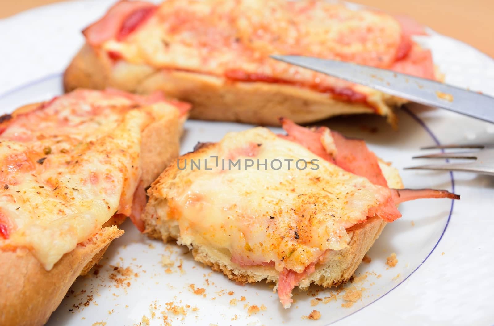 Remains of the ham and cheese baked toast on the plate.